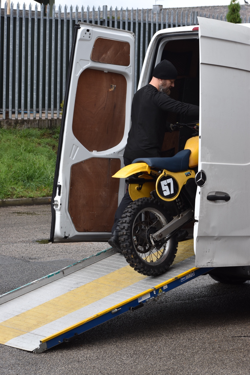 Greg guiding a classic yellow motorcycle on the loading ramp