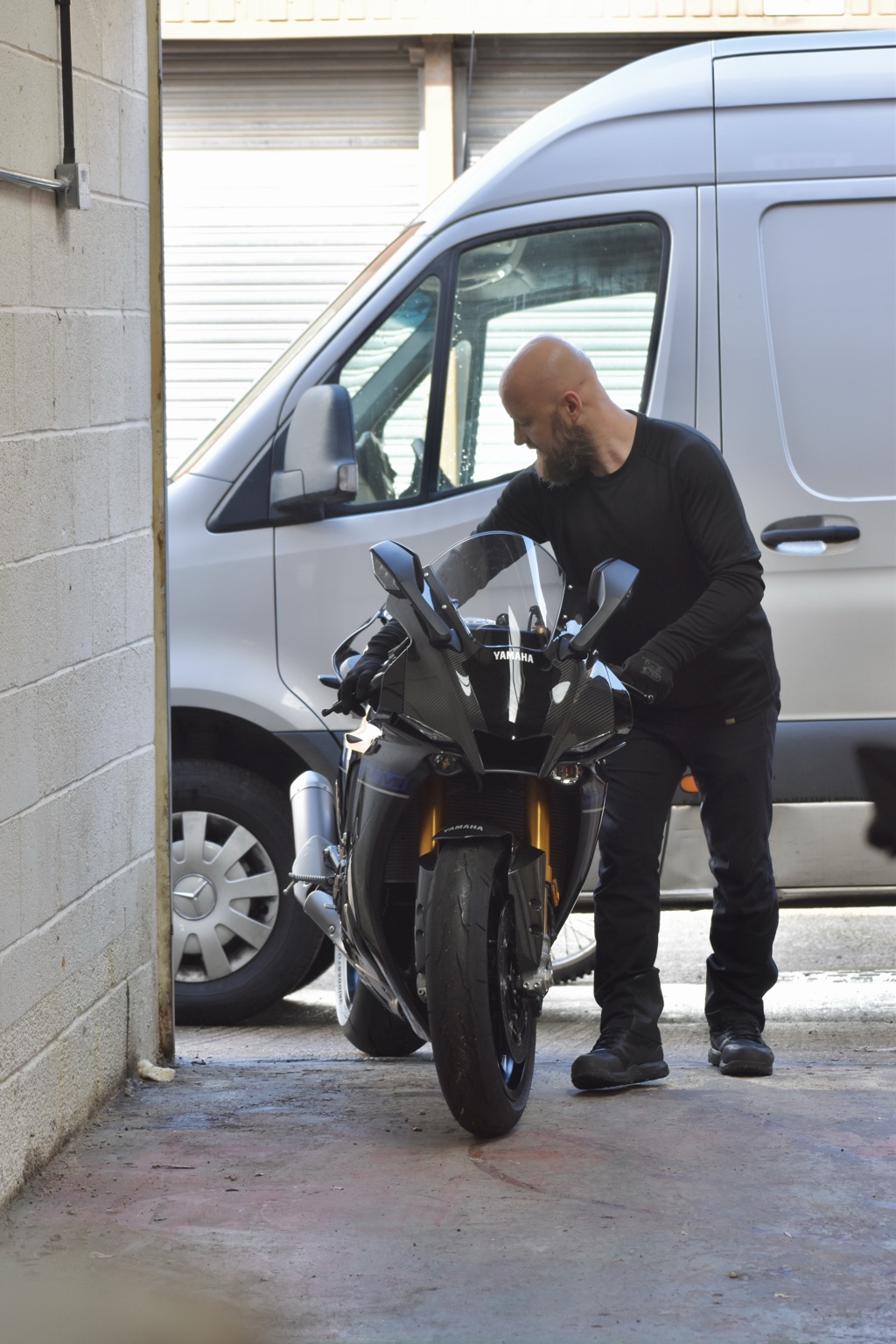 Greg carefully guiding a motorcycle into the unit